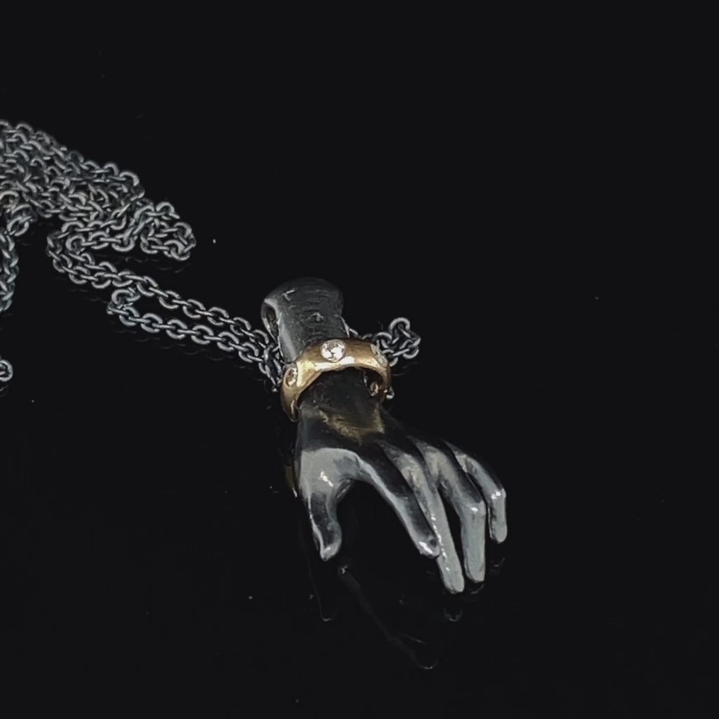 Video of Sam Lafford's Contemporary Oxidised Silver Helping Hand with 9k Yellow Gold Diamond Bangle Necklace. Available on DESIGNYARD.com and in our Jewellery Shop Dublin Ireland. Free Worldwide Shipping with DHL.