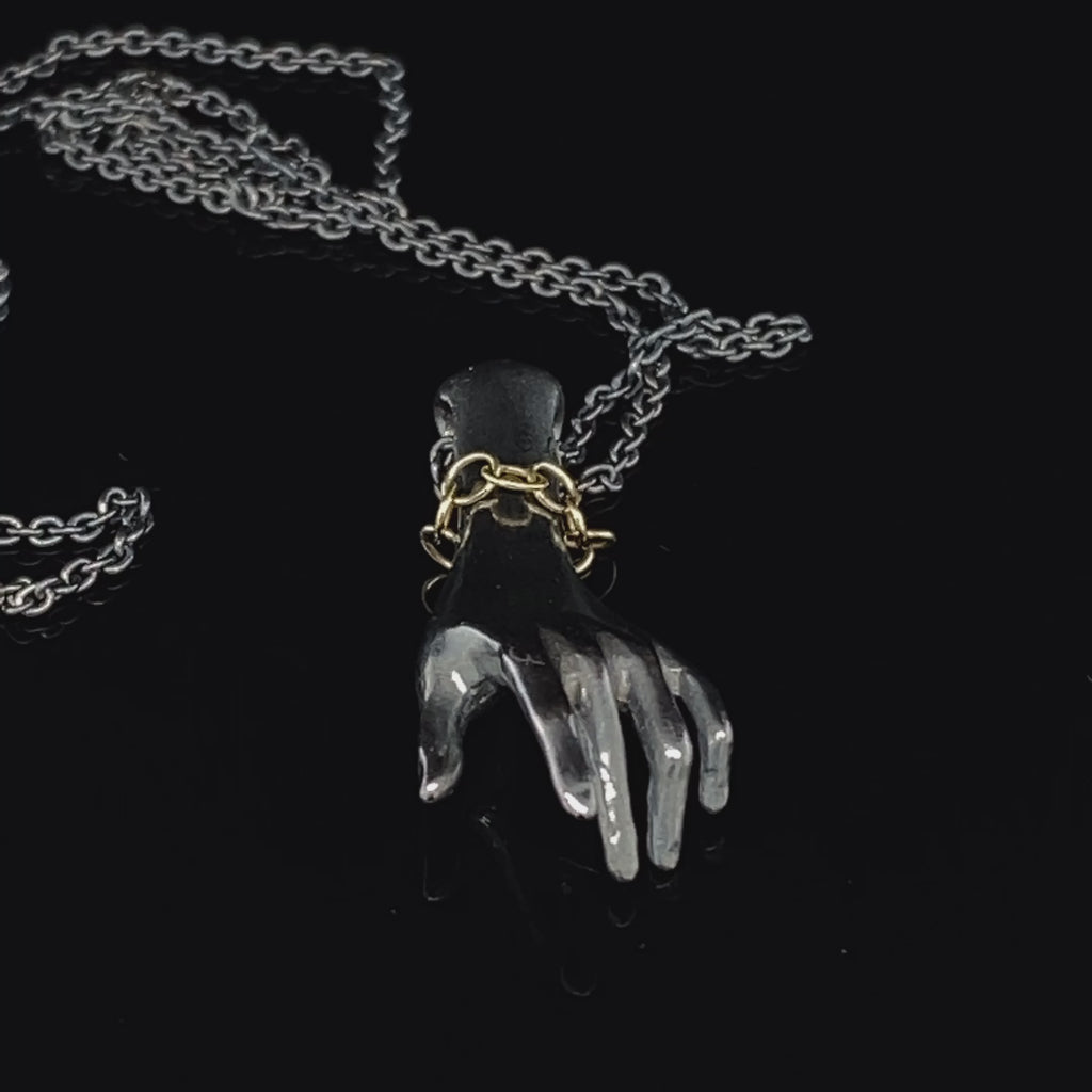 Video of Sam Lafford's Contemporary Oxidised Silver Helping Hand with 9k Yellow Gold Bracelet Necklace. Available on DESIGNYARD.om and in our Jewellery Shop Dublin, Ireland. Free Worldwide Shipping with DHL.